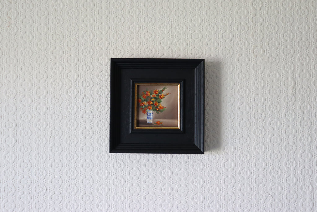 Small framed painting of a floral arrangement on a textured white wall Original oil painting of an autumnal trio of flowers or fruits, warm amber and rust tones still life