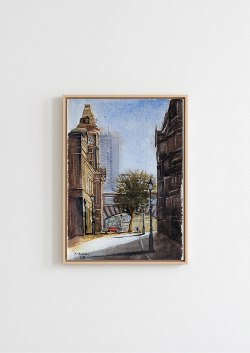 A framed watercolor painting of a city street scene with buildings, a tree, and a red car, displayed on a clean white wall. Birmingham Museum and Art Gallery from Edmund Street - limited edition fine art print by Marta Stolarska, based on original watercolour, A4 archival matt paper, edition of 50, hand signed and numbered