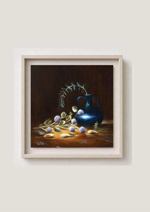 A framed still life painting featuring a glossy blue vase with green leaves and small purple flowers on a warm brown tabletop, set against a dark brown background, enclosed in a light beige frame. Still life painting with a blue jug, green leaves, and purple berries on a dark background. Chiaroscuro sculptural techniques.