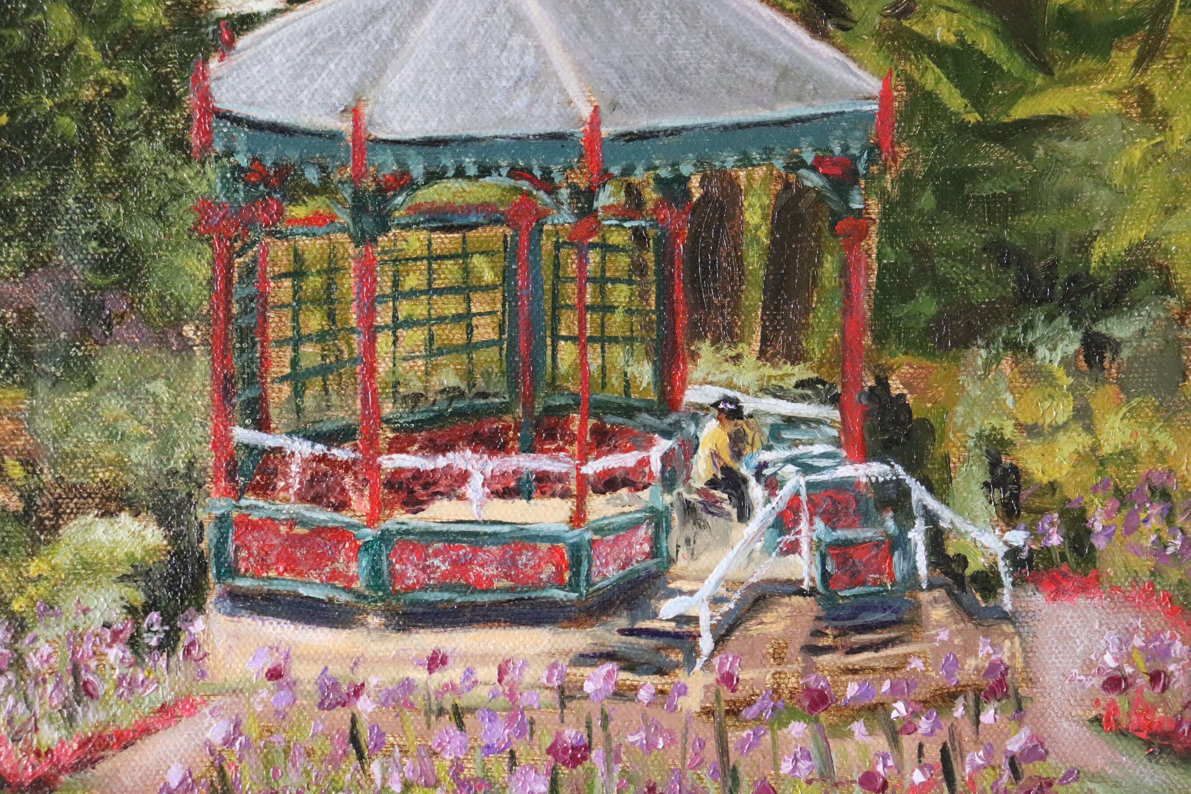 Colorful gazebo in a garden with flowers and people around