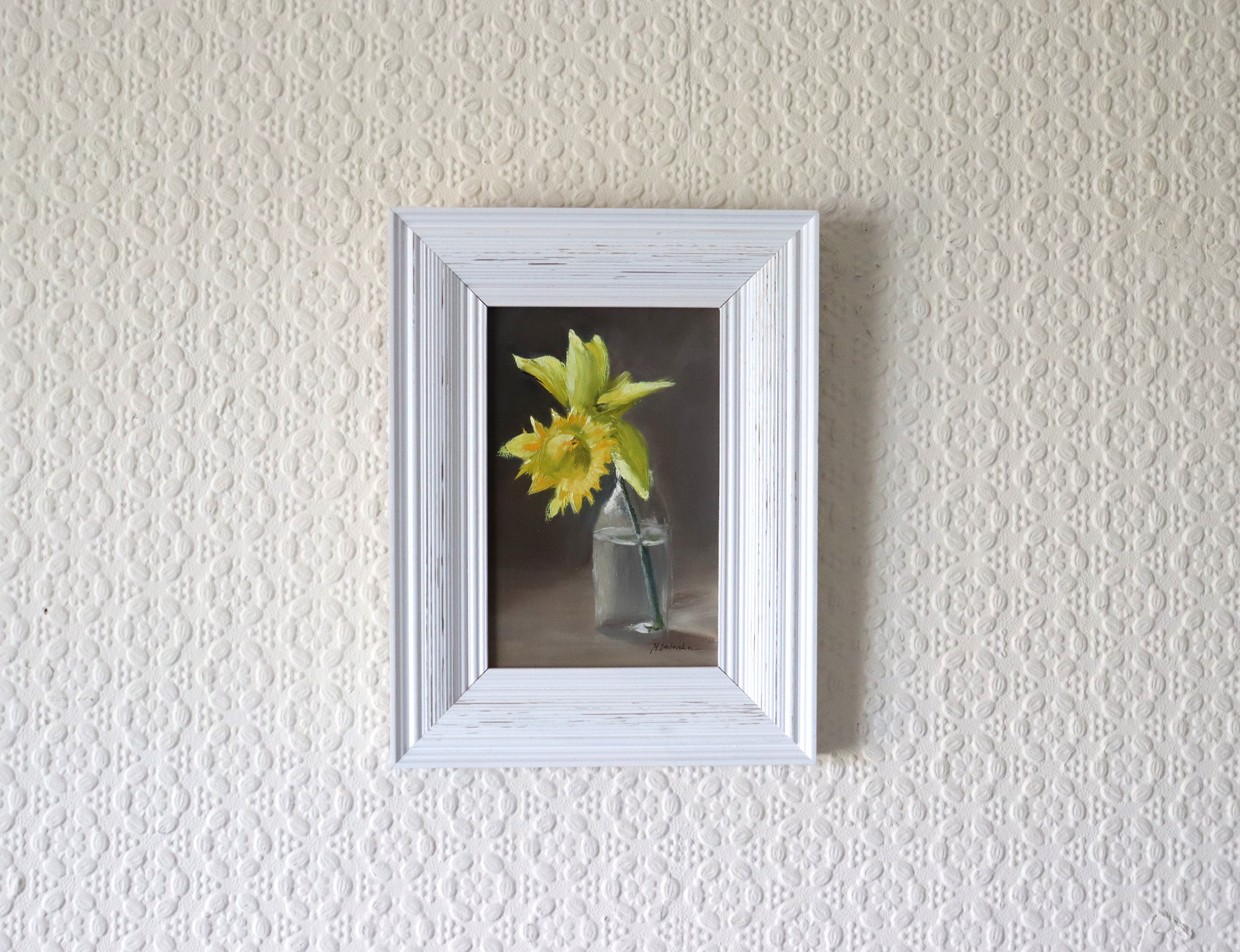 One Daffodil is All You Need original oil painting hung on a wall - yellow daffodil in glass bottle in modern white wooden frame, approx. 18.5 x 23.5 cm, by Marta Stolarska Fine Art, ready to hang