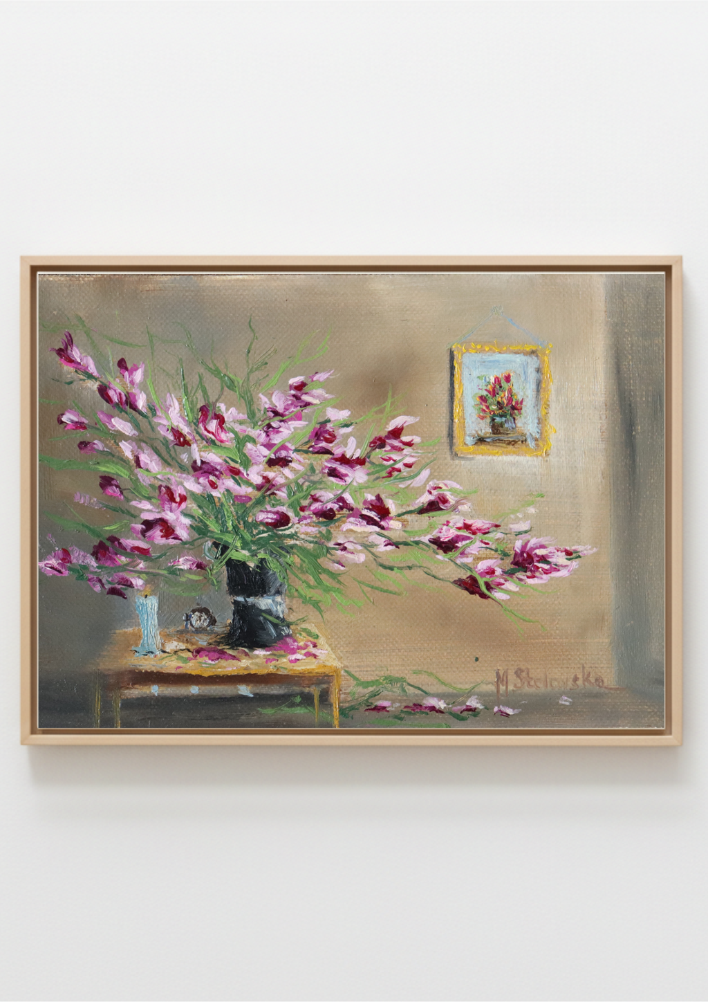 A framed still life painting featuring a bouquet of pink and purple flowers on a table against a beige wall, with a small framed artwork hanging on the wall. Forgotten in Late Summer Heat - original oil painting by Marta Stolarska, an overgrown magenta houseplant in a dark vase on a side table with a clock and unlit candle, imagined composition on handmade linen board, 15 x 10 cm landscape