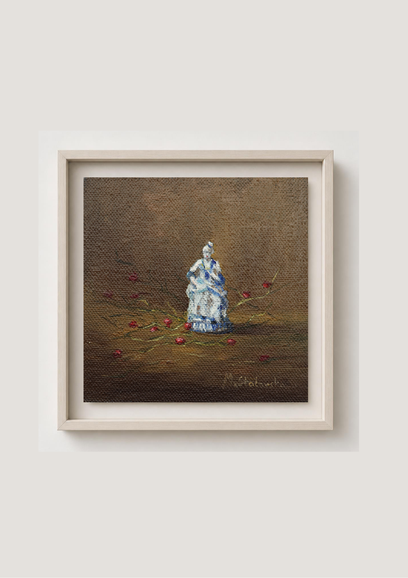 A framed painting on canvas featuring a small white porcelain doll seated on a brown textured background with scattered red flowers. The artwork is housed in a light beige frame and displayed against a neutral light gray wall.