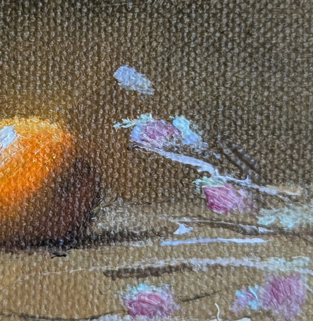 Close-up of a textured surface with floral elements and an orange object. Original oil painting of a glowing orange surrounded by delicate flowers, bold citrus against soft florals