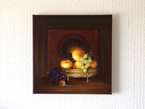 Classical still life oil painting with oranges, grapes and a gold vessel, painted in the tradition of Caravaggio and Rembrandt