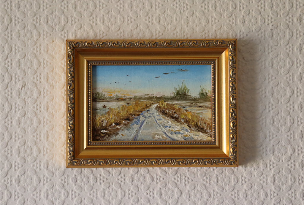 Painting of a rural landscape with a path, fields, and birds in the sky by a local artist. Original oil painting of geese in flight over snowy Oulton Broad marshes, snow-covered bridleway leading into scene