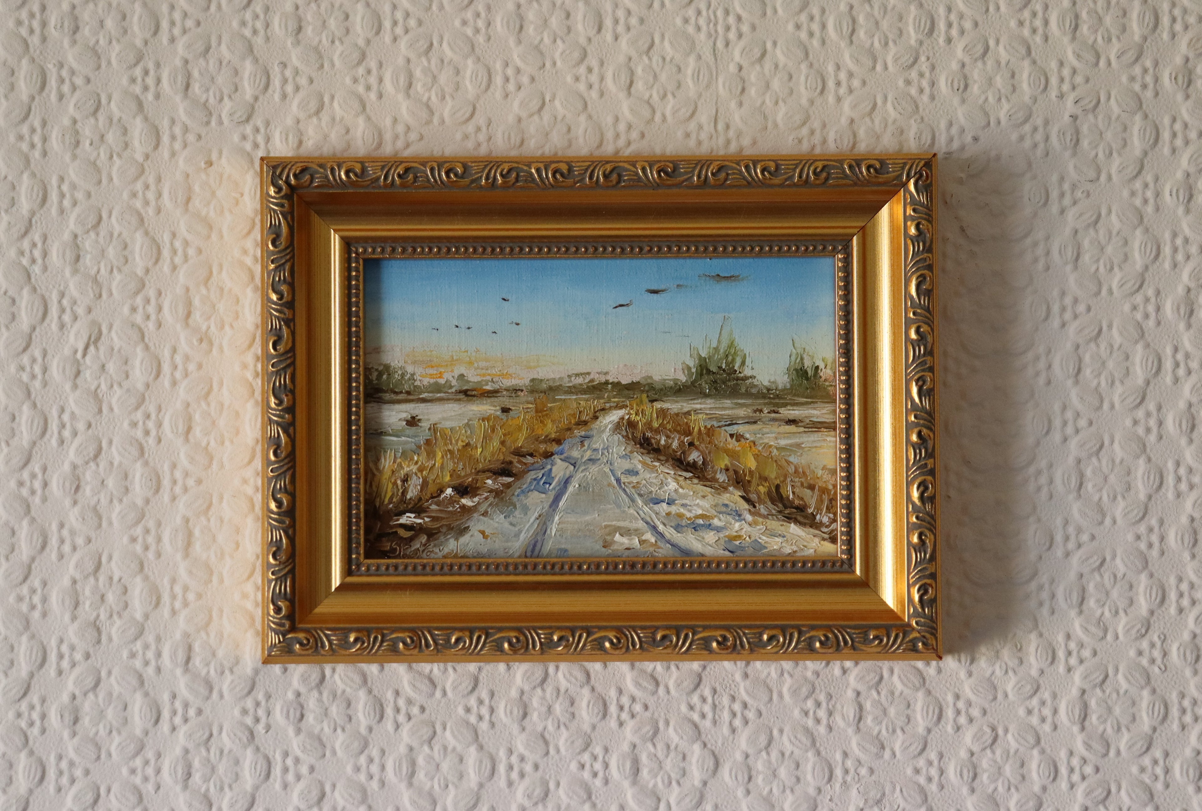 Painting of a rural landscape with a path, fields, and birds in the sky by a local artist. Original oil painting of geese in flight over snowy Oulton Broad marshes, snow-covered bridleway leading into scene