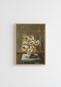 A framed still life painting of a vibrant flower bouquet on a table, hung on a plain white wall. May Abundance - original oil painting by Marta Stolarska, an overflowing spring bouquet of pink roses and white flowers in a vase on a taboret with notebooks, painted from life on handmade linen board, 10 x 15 cm