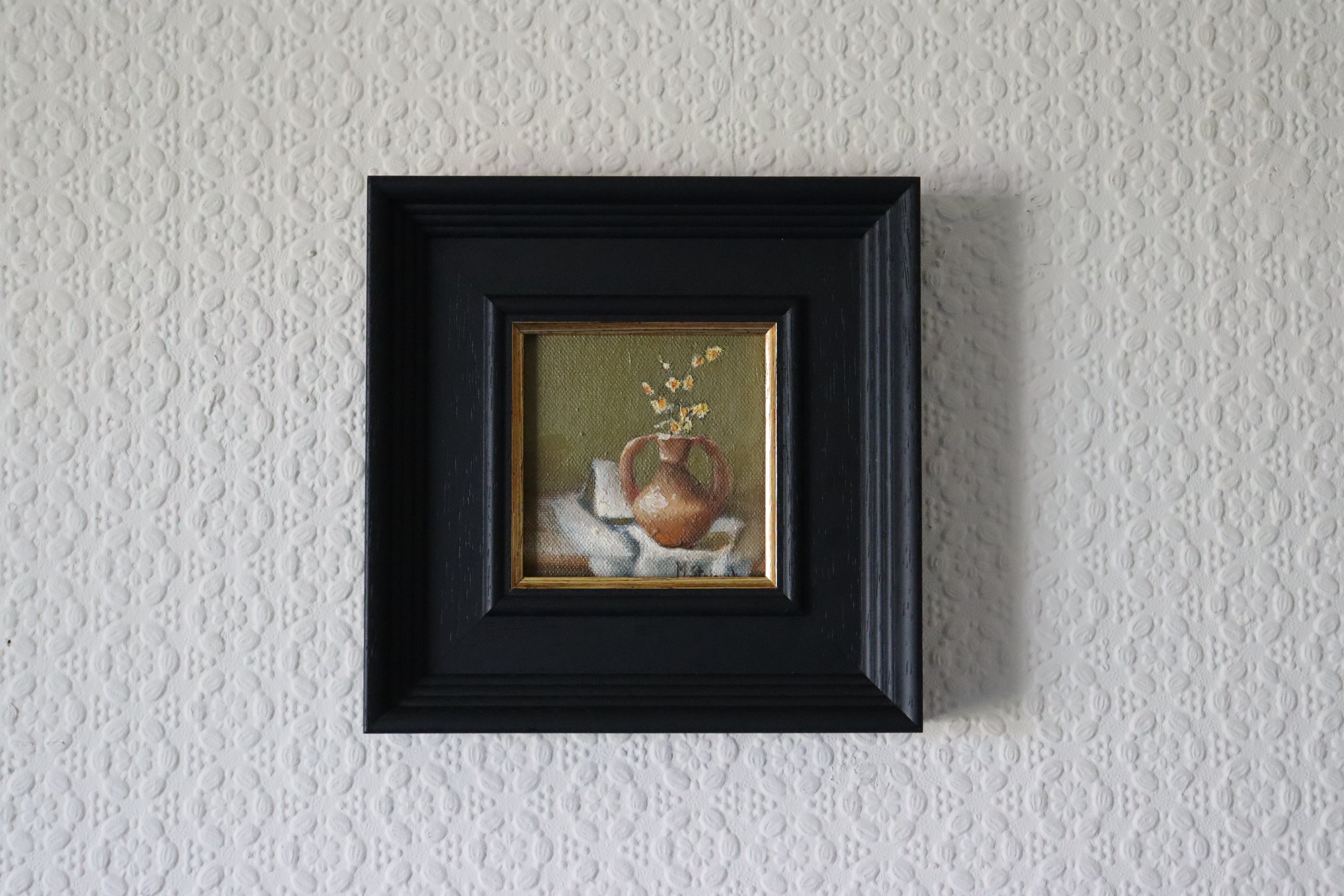 Framed Original oil painting of old terracotta, aged ceramic pot in warm earthy tones still life Small painting of a still life scene in a black frame on a textured wall.