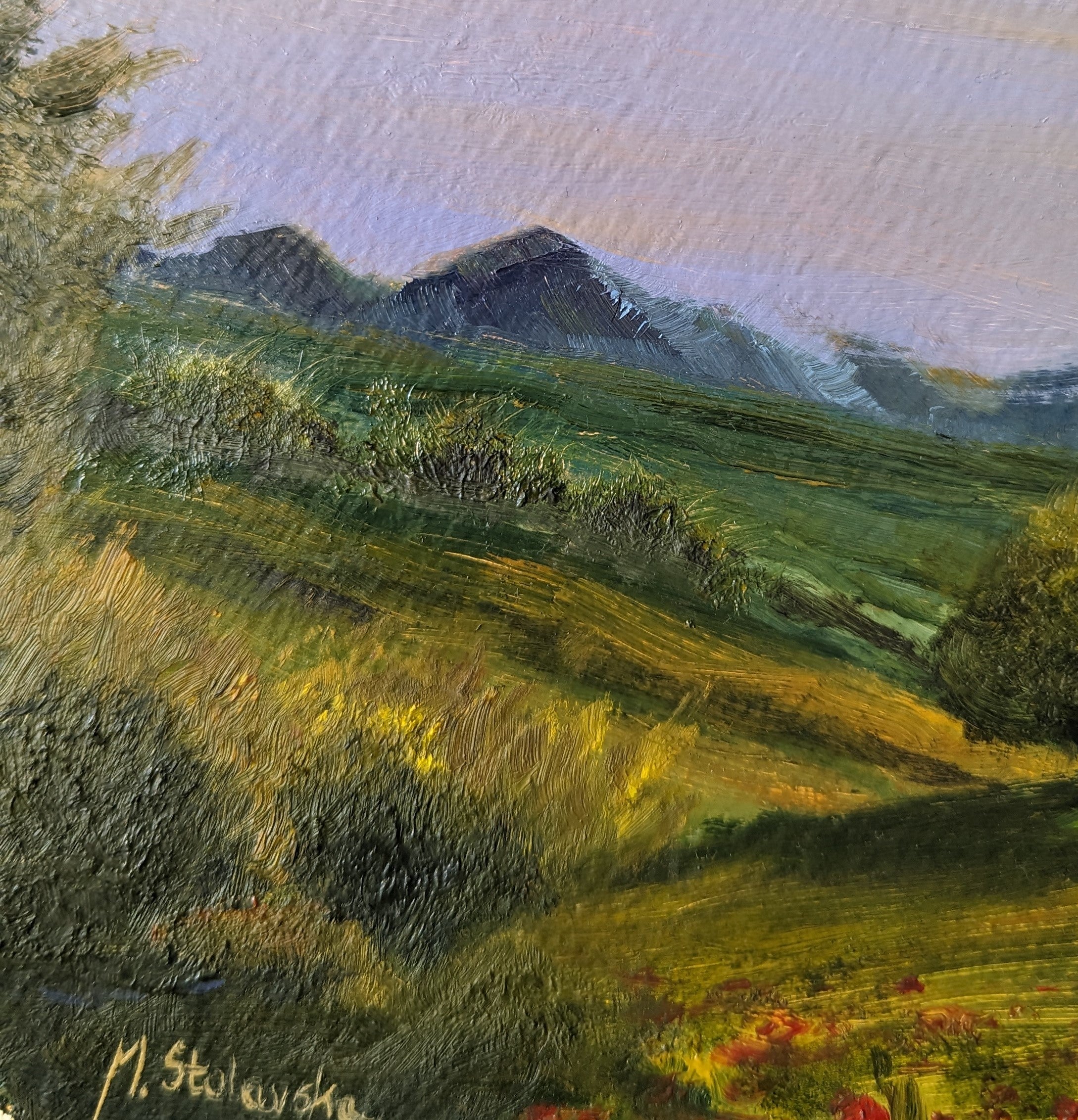 Painting of a landscape with green fields and mountains in the background. Original round oil painting of a summer evening in central Poland with poppies and setting sun, childhood memory, 30cm