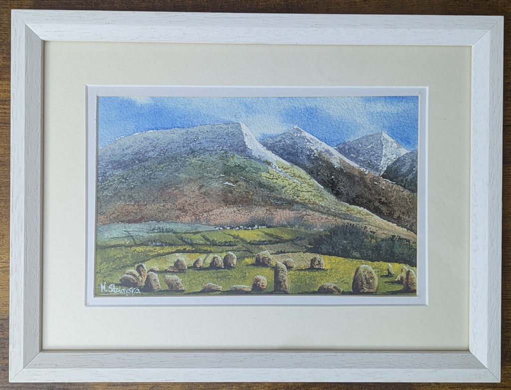 Original watercolour painting of Castlerigg Stone Circle with snow-capped Lake District fells behind, light airy sky, framed