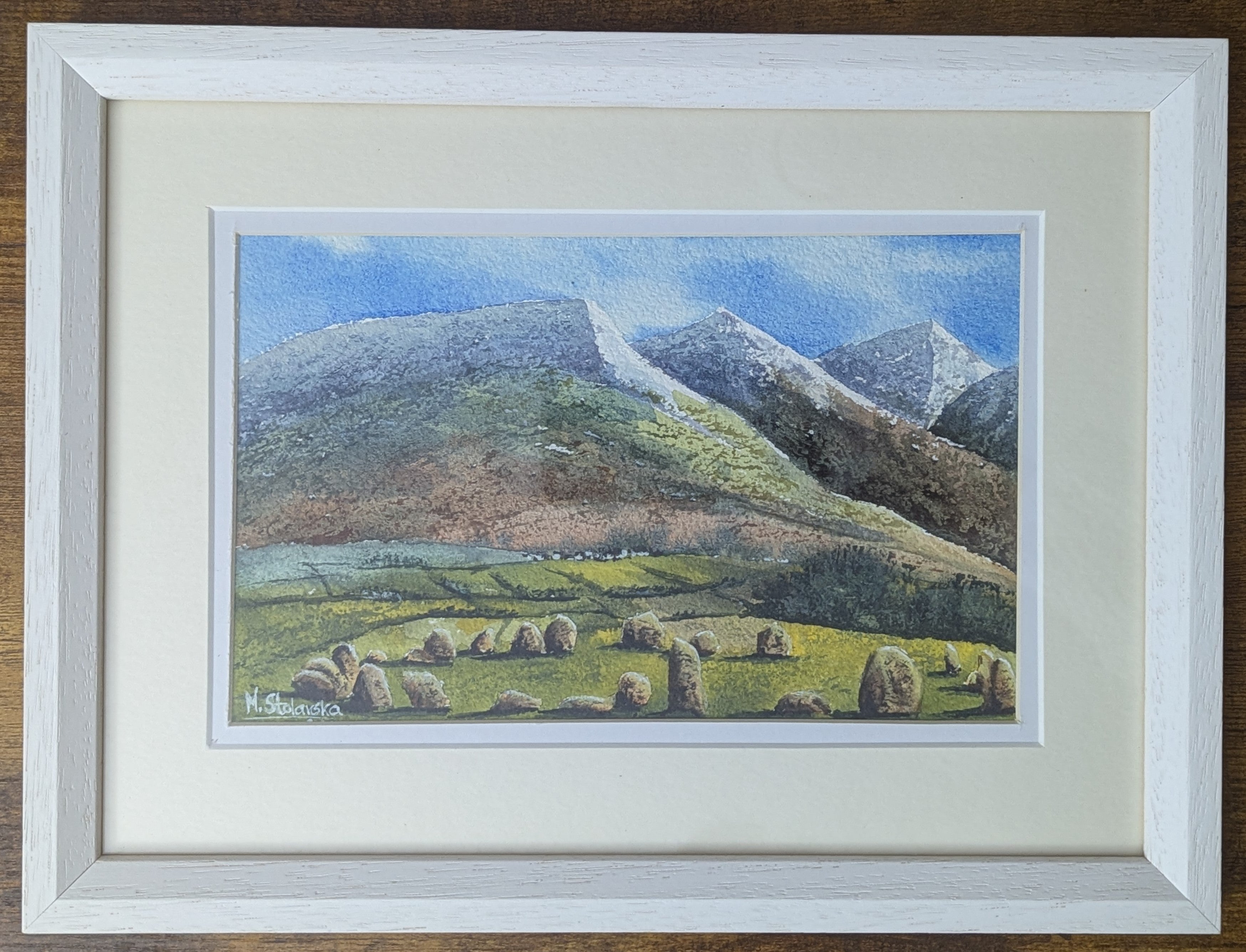 Original watercolour painting of Castlerigg Stone Circle with snow-capped Lake District fells behind, light airy sky, framed