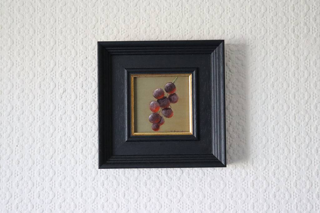 Framed artwork of grapes on a textured white wall Original oil painting of juicy grapes, lush fruit still life with rich purple tones by Marta Stolarska