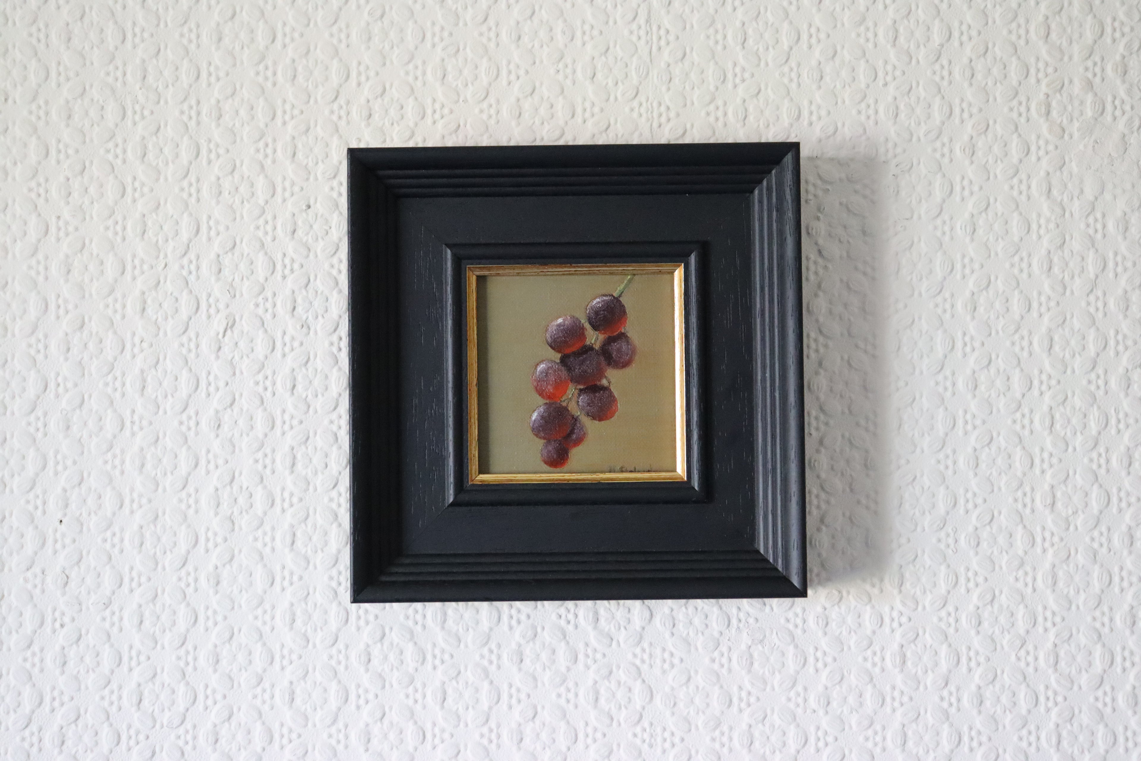 Framed artwork of grapes on a textured white wall Original oil painting of juicy grapes, lush fruit still life with rich purple tones by Marta Stolarska