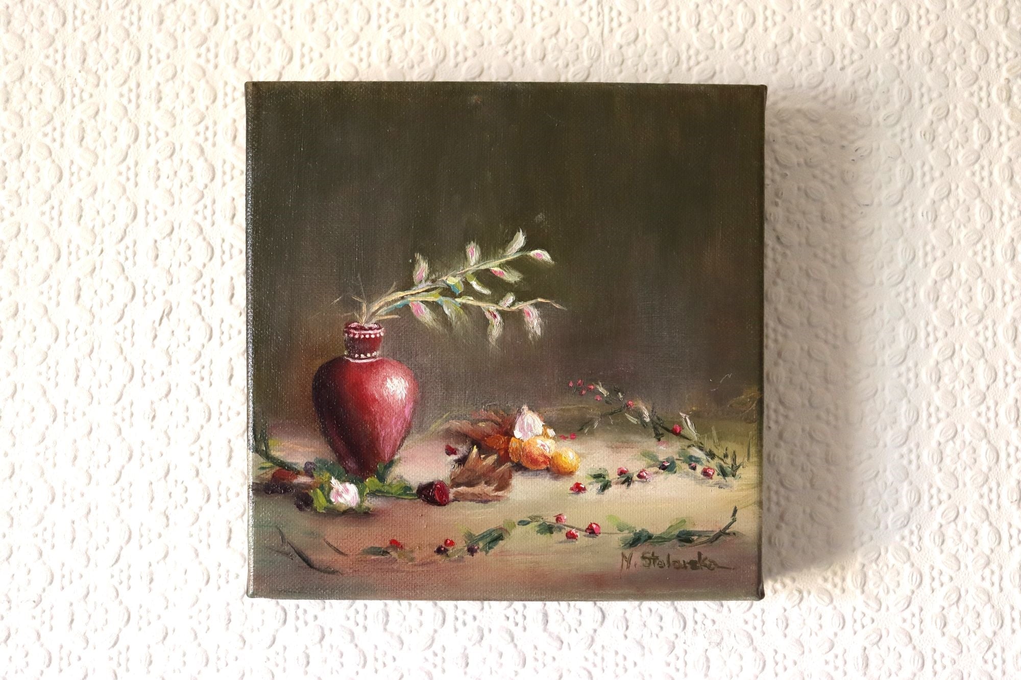 The Spirit of Midwinter original oil painting hung on a wall - festive winter still life with berries, oranges and red vase, deep edge canvas 20x20cm by Marta Stolarska Fine Art