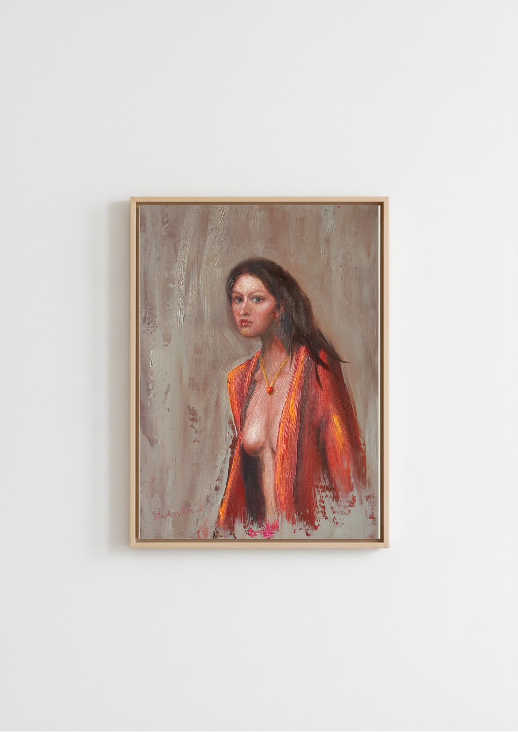 A framed portrait painting of a woman with dark hair, wearing a bright orange-red shawl, hanging on a plain white wall. The Interrupted Moment - original oil figure painting by Marta Stolarska, dark-haired woman in slightly open red robe turning to look back at viewer, oil on canvas board, gold frame 25.5x30.5cm