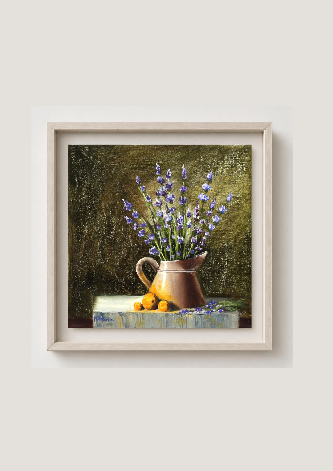 A framed still life painting featuring purple lavender in a brown pitcher with small yellow fruits, displayed on a light beige wall. The Lavender Harvest - original oil still life by Marta Stolarska, lavender in bloom arranged in a watering can on grey stone slab with green garden background, oil on cradled wooden canvas panel, 30x30cm