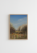 A framed landscape painting featuring a rustic fence, wildflowers, trees, and a blue sky, displayed on a plain white wall. Painting of a rural landscape with a wooden fence, grass, and trees under a blue sky. Original oil painting of a path towards the meadows at Carlton Marshes Suffolk, dilapidated fence and open fields
