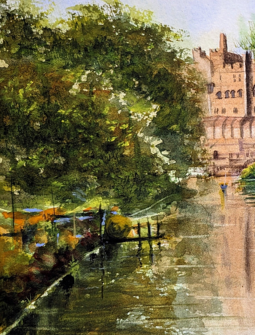 Painting of a castle by a river with trees in the foreground. Castle by a river with lush greenery. Work by a local artist. Original watercolour painting of Warwick Castle from the River Avon Warwickshire, medieval fortress built 1068