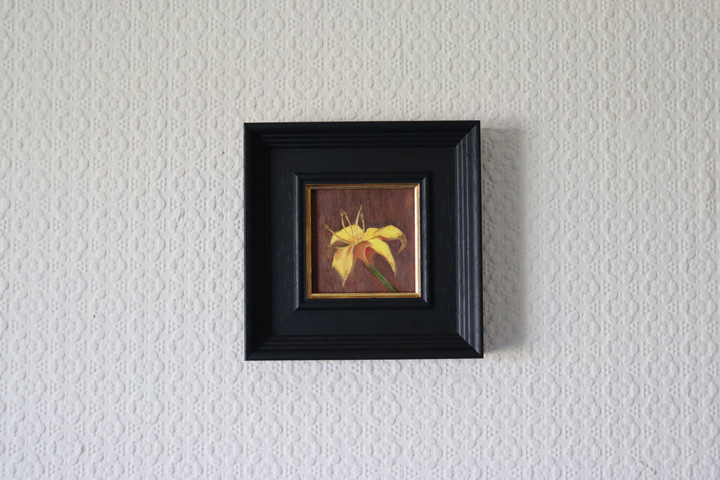 Small framed artwork of a yellow flower on a textured white wall Original oil painting of a yellow lily, vibrant floral still life by Marta Stolarska Fine Art