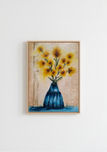 Framed wall art featuring a textured painting of yellow sunflowers in a blue vase, displayed on a clean white wall.